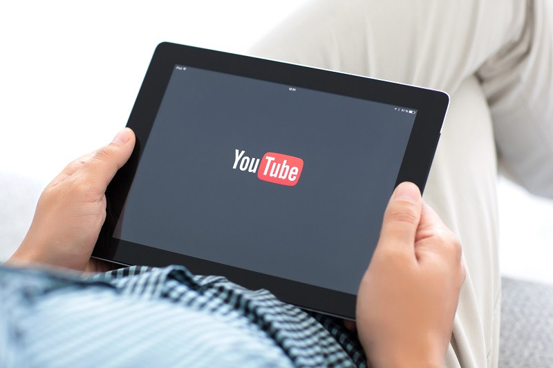 A person holding a tablet using YouTube.