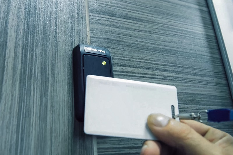 A person uses an ID card to open a door.