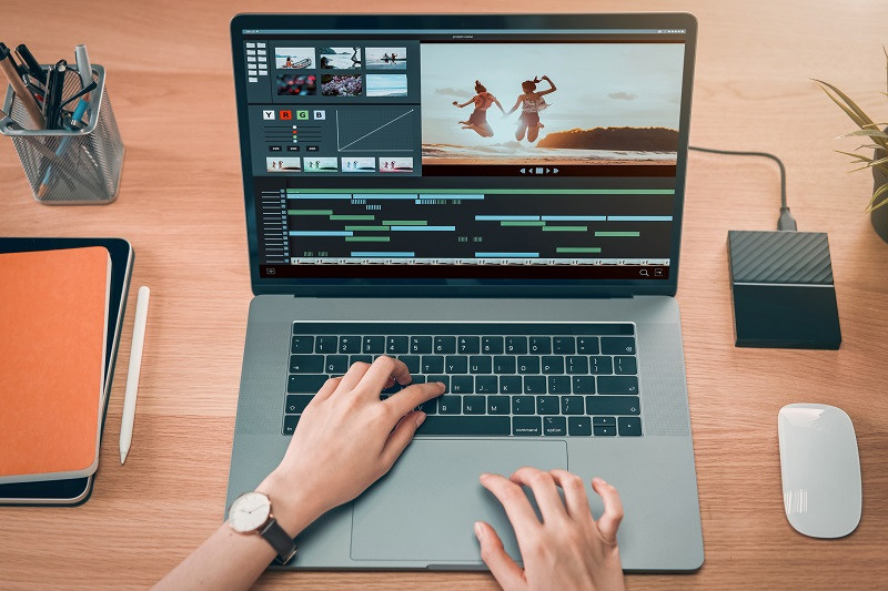 A person editing video on a laptop.