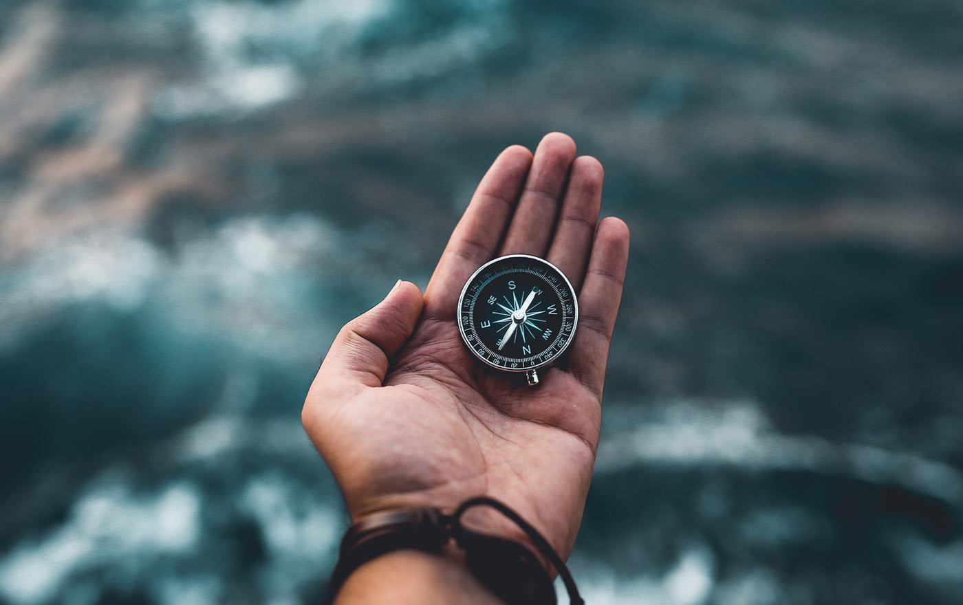 A person holding a compass in their hand.
