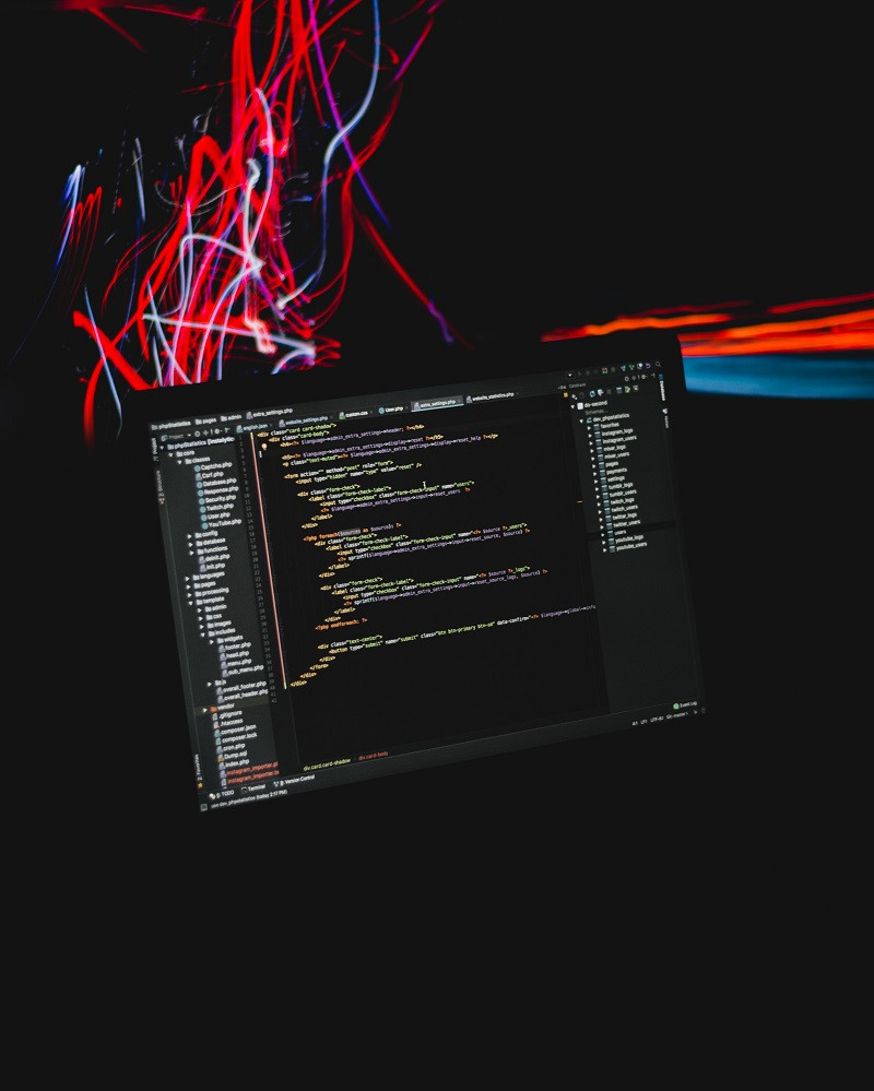 A computer with colorful digital streams above it.