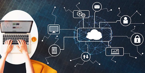 A laptop next to illustrated cloud graphics.