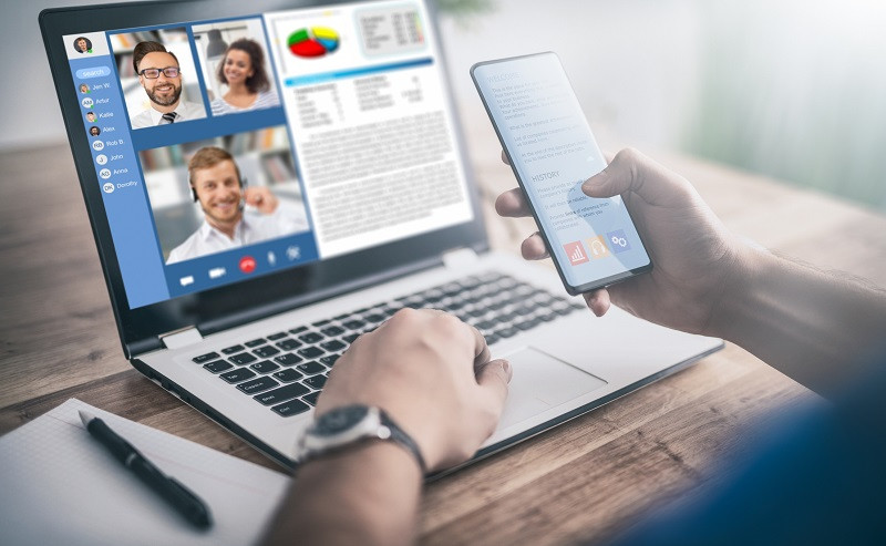 A worker has a meeting on his laptop.