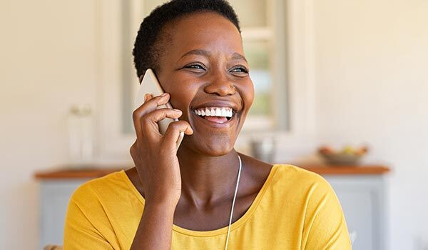 A woman smiling while on the phone.