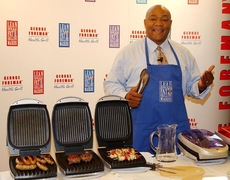 A picture of George Foreman by his signature grill.