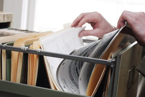 hands going through files in a filing cabinet 