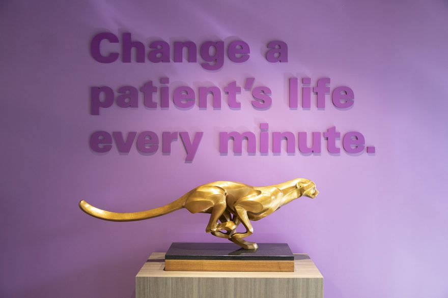 A sculpture of Nuvasive's iconic cheetah mascot in front of the company's slogan.