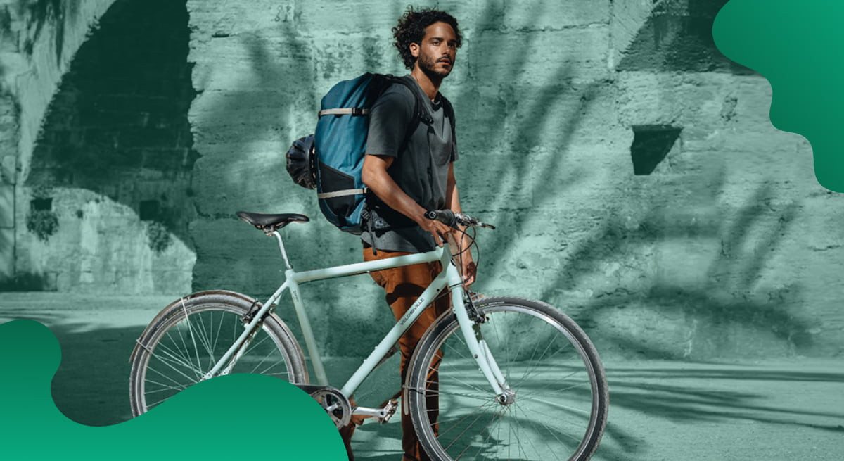 Schwalbe header image in green of bicyclist walking their bike.
