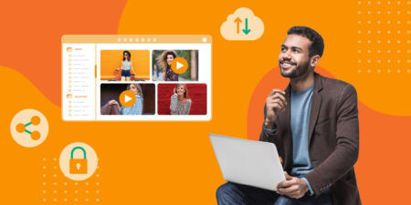 Person with laptop looking at cloud-based DAM platform over an orange background