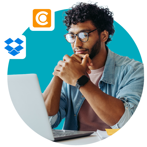 Person comparing DAM vs Dropbox on a laptop over a blue background