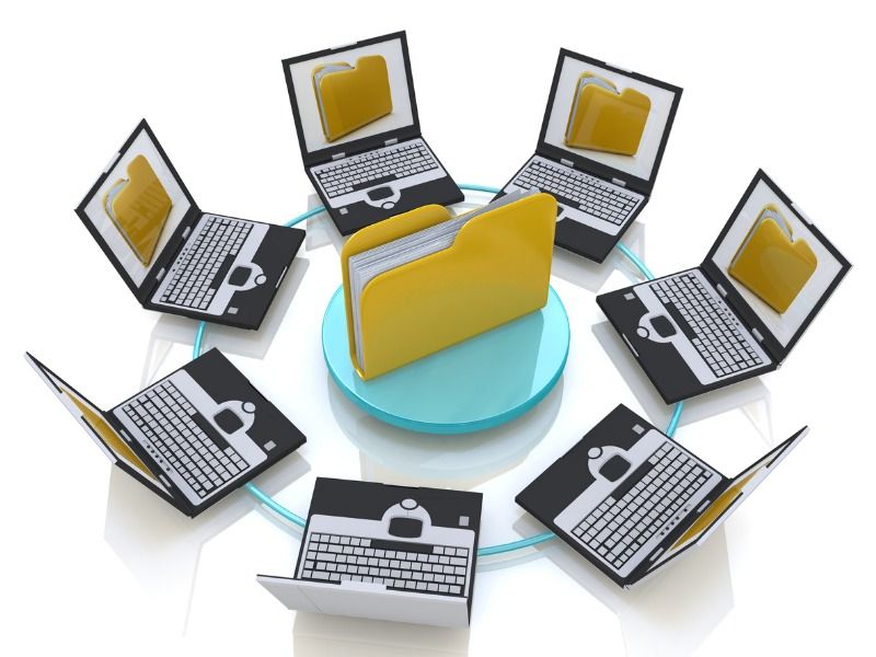 Eine Datei steht symbolisch in der Mitte eines Kreises von Laptops, die diese Datei als Abbildung auf ihren Bildschirmen zeigen.