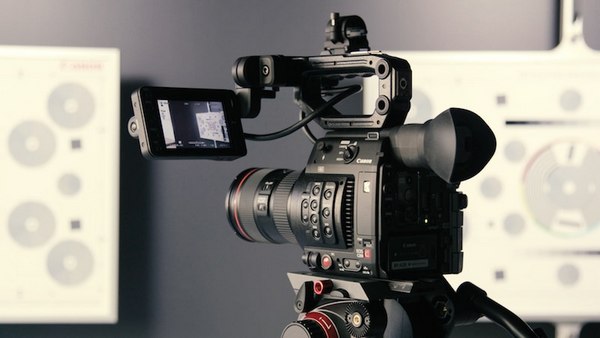 Eine Filmkamera, die in einem Raum steht und auf etwas im Hintergrund ausgerichtet ist.